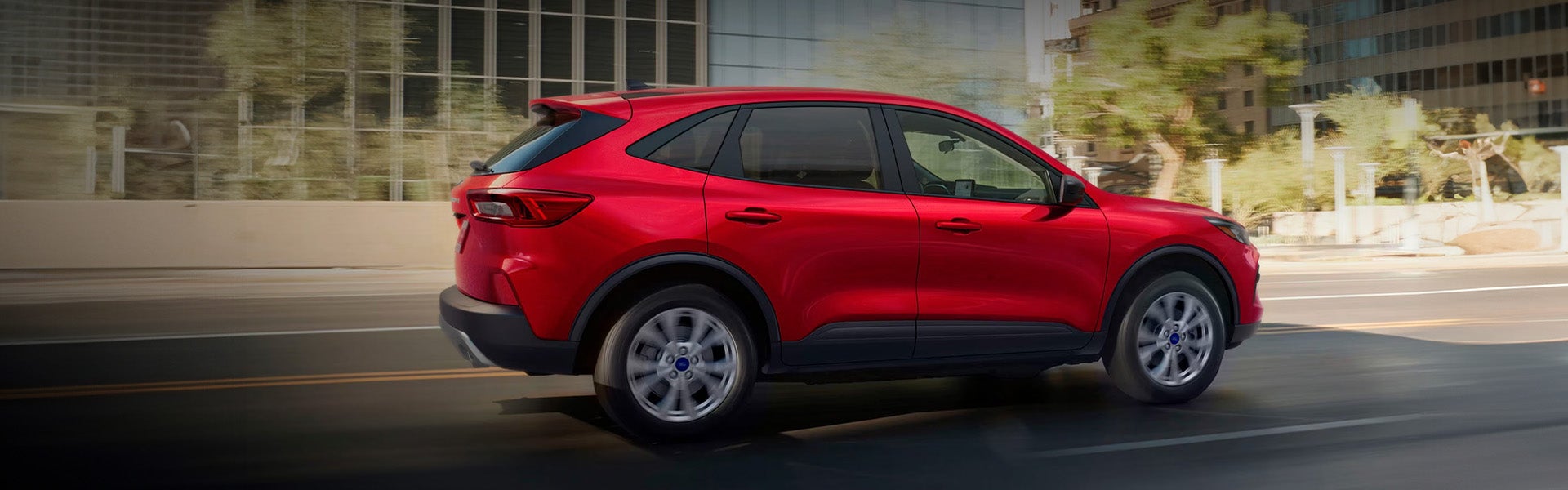 Two people standing next to a ford escape.