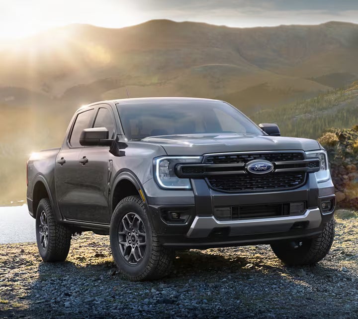 A gray truck sitting parked outdoors.