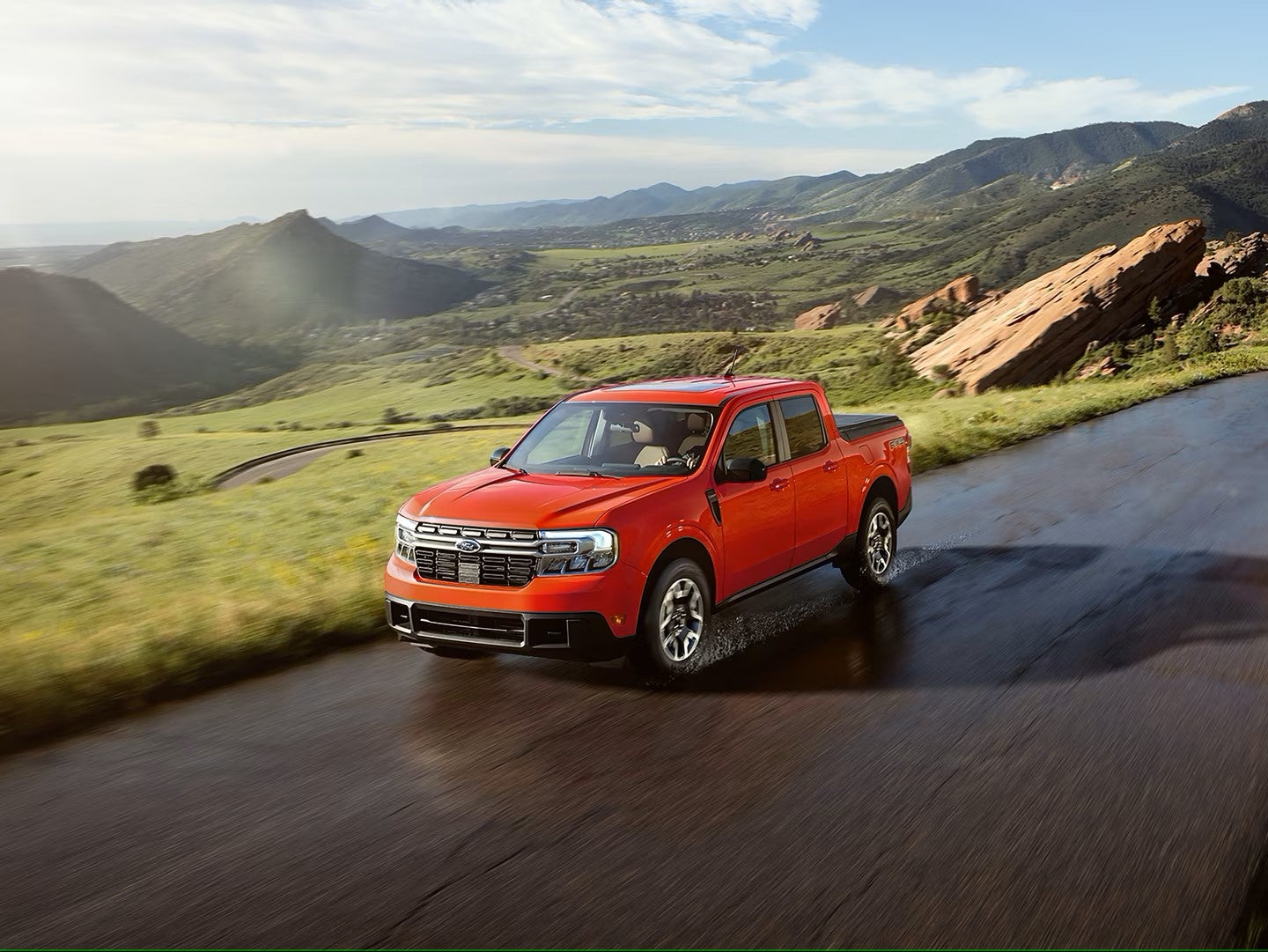 a red truck driving on a paved road