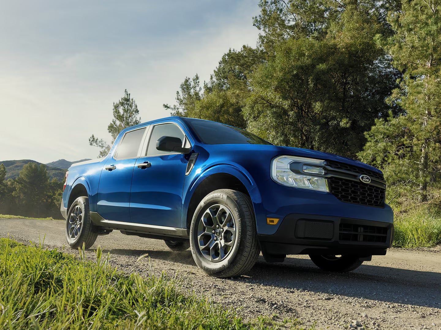a blue truck driving on gravel road