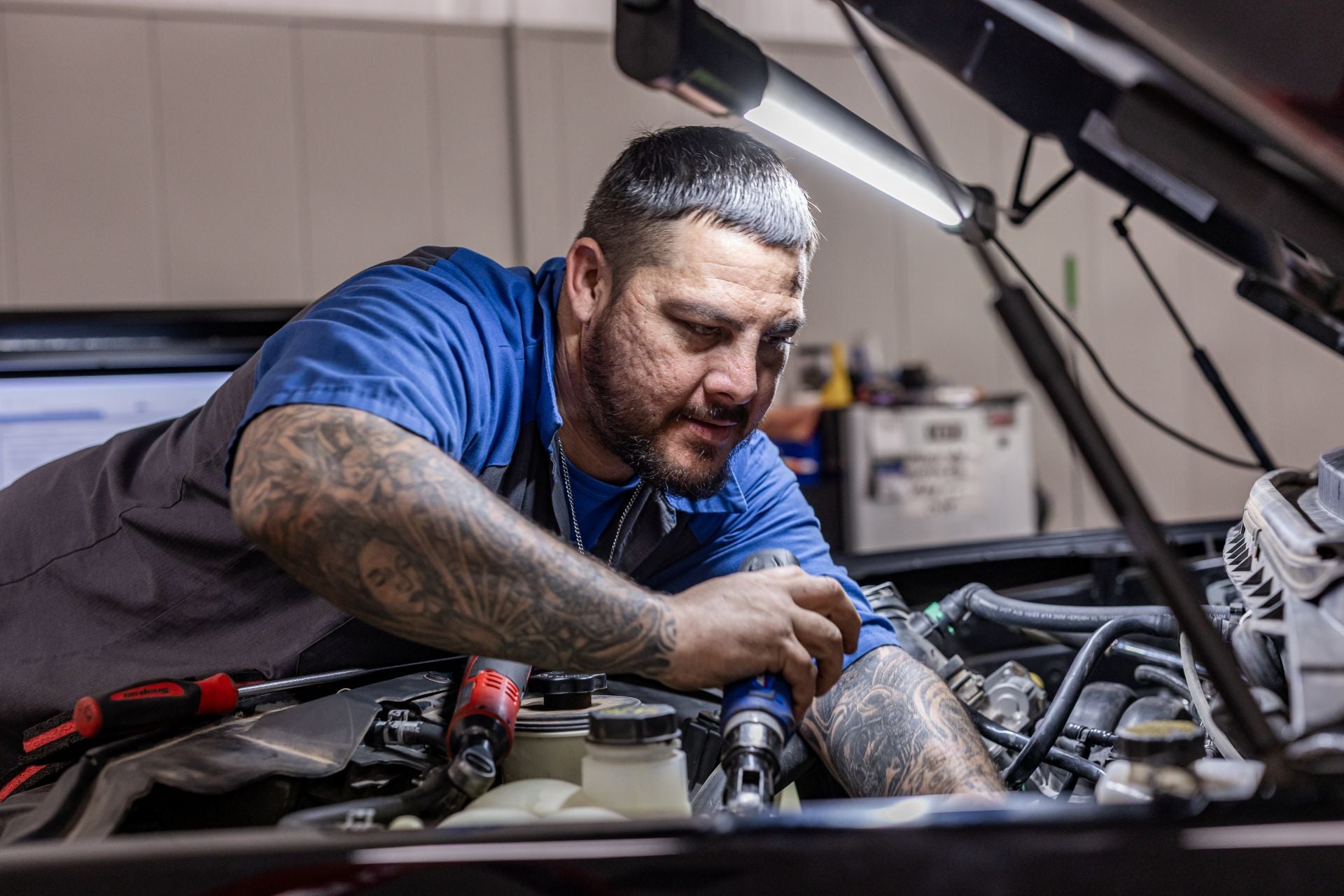 ford technician working under the hood of a vehicle