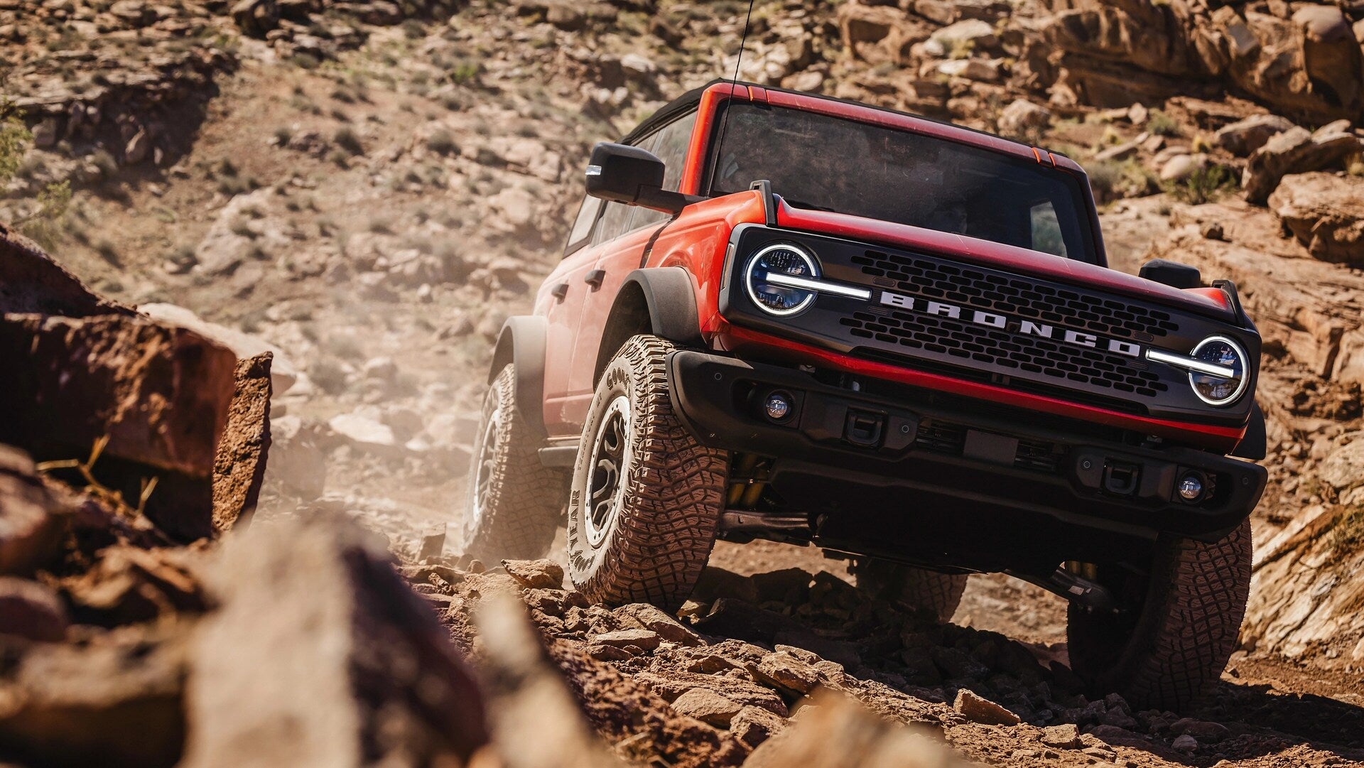 A red bronco driving off-road.