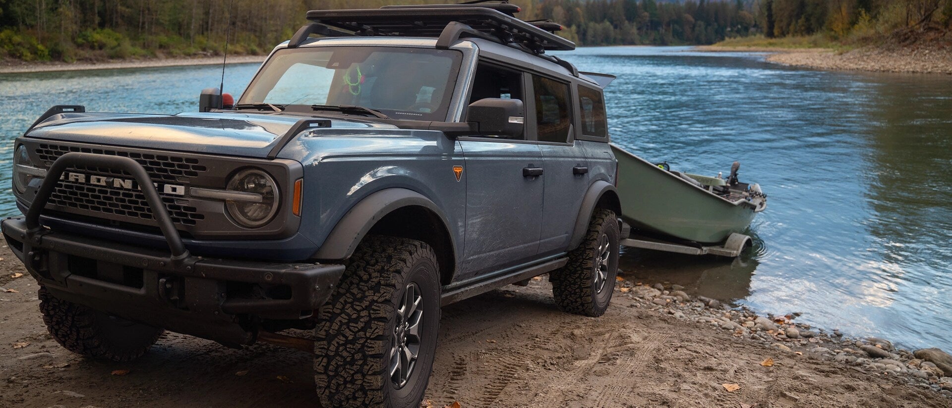 A blue bronco pulling a boat.