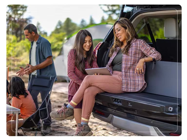Family enjoying time together at a campsite with the Ford Expedition’s tailgate open for convenience.