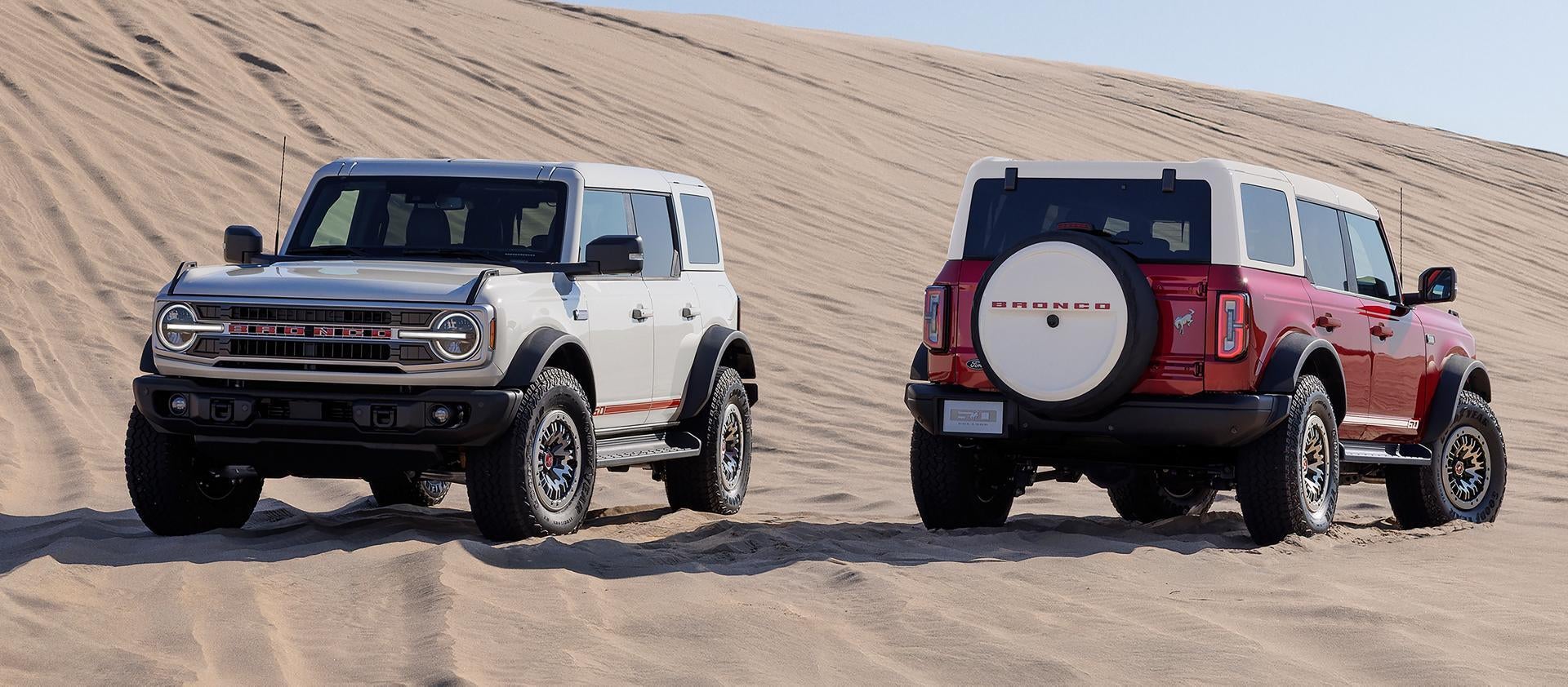 two 2026 Ford bronco's parked next to each other in desert