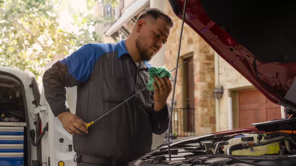 a ford service doing an oil change on a 2026 Ford Maverick