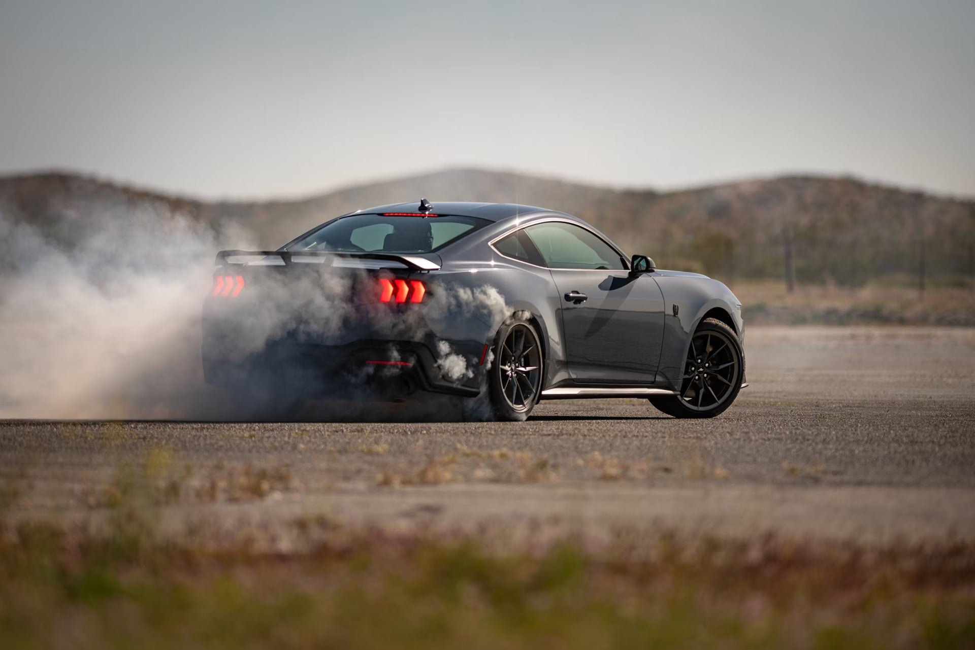 a new 2026 Ford Mustang performing a drift in a empty out parking lot
