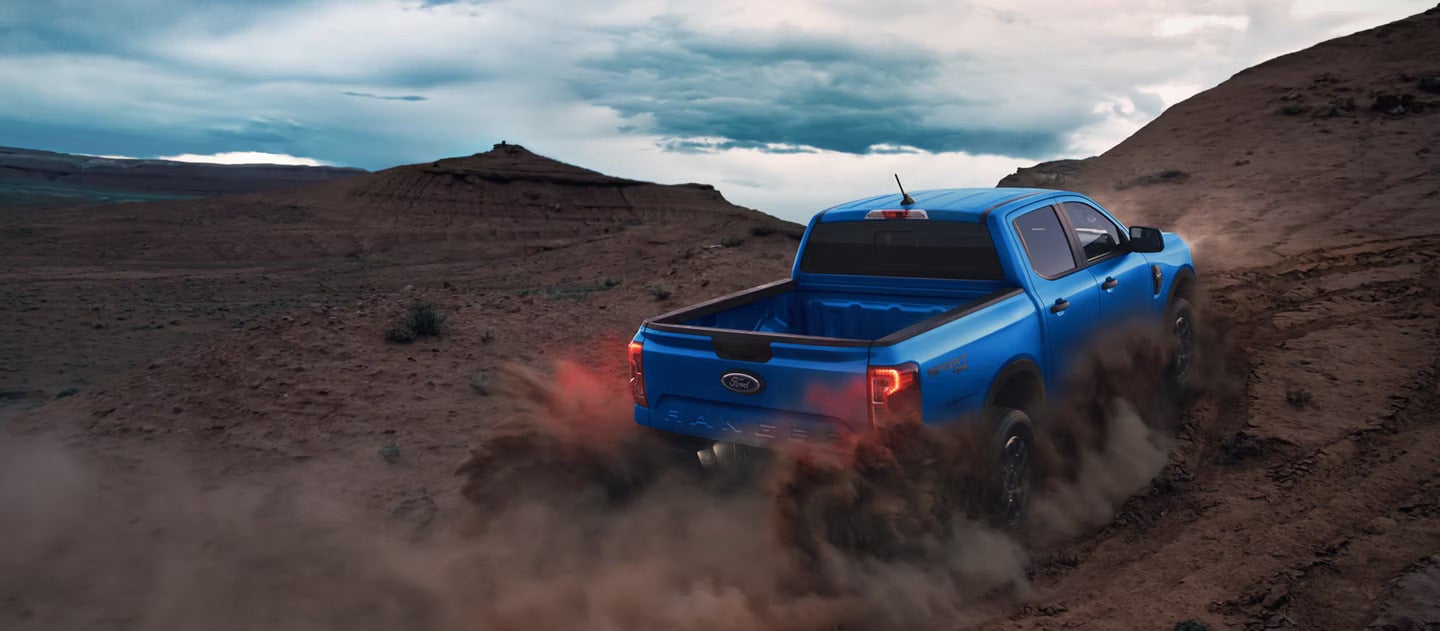 A blue truck driving off-road.